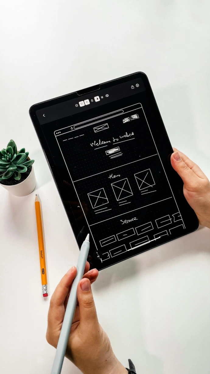 person holding black ipad with green plant
